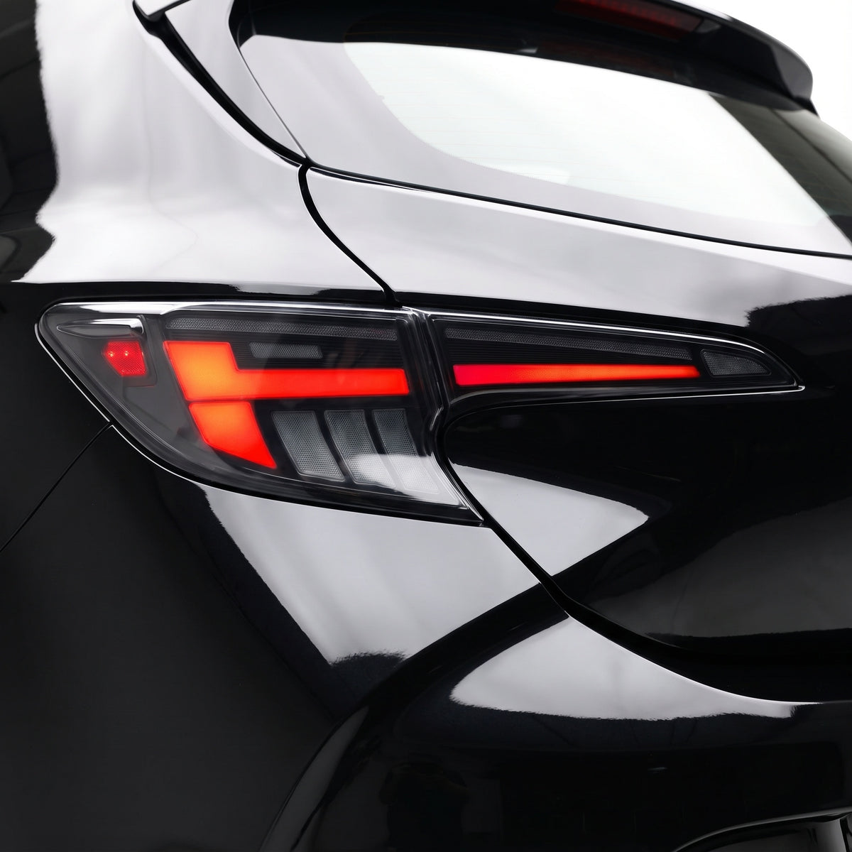 Toyota Corolla E210 Hatch (2019 - 2024) Black Red LED Sequential Tail Lights LH + RH installed close-up