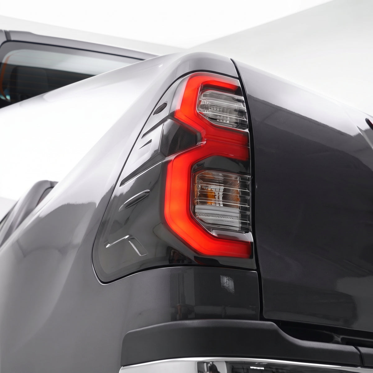 Toyota HiLux N80 / Revo Rocco (2015 - 2025) Smoked MY12 Update Style 3D LED Stripe Bar Tail Lights LH + RH installed close-up