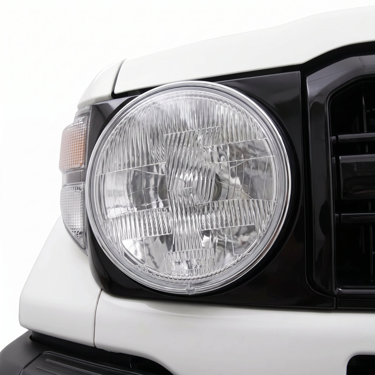 Toyota LandCruiser 70 / 73 / 75 / 78 / 79 Series (1985 - 2007) H4 7-inch Round OEM Style Headlights LH + RH installed close-up